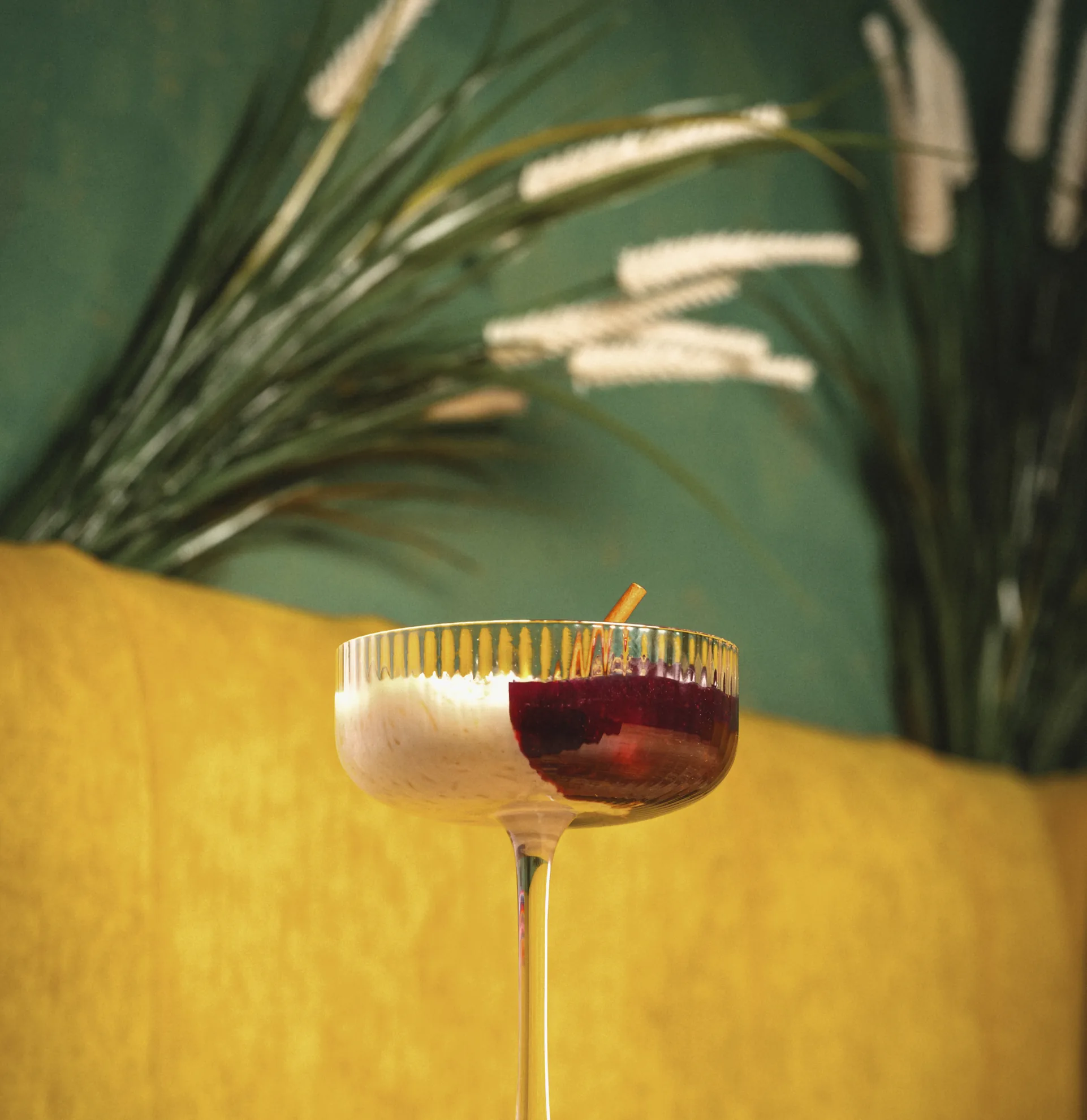 A Pachamama cocktail on the bar, against the restaurant's yellow and green walls