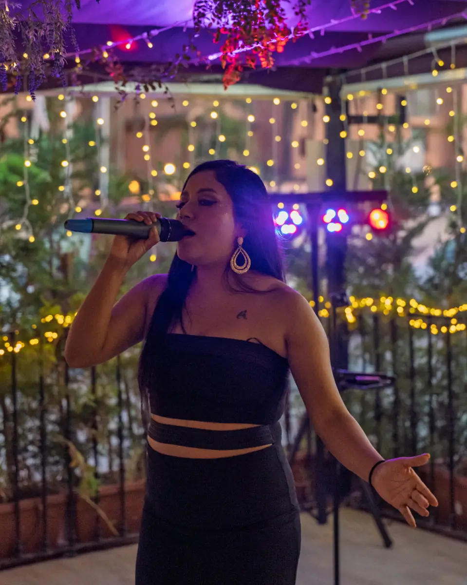 A singer lit in blue on the terrace at Pachamama