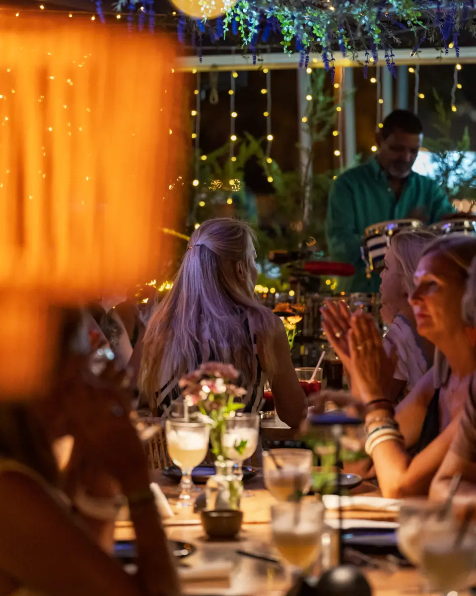 Guests applauding at a full table during a live show at Pachamama