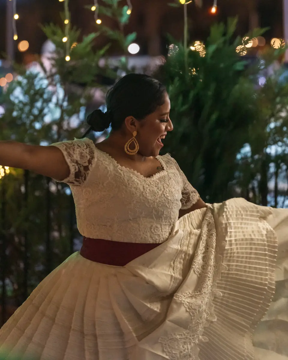 A dancer in a white Peruvian marinera dress mid-turn at Pachamama