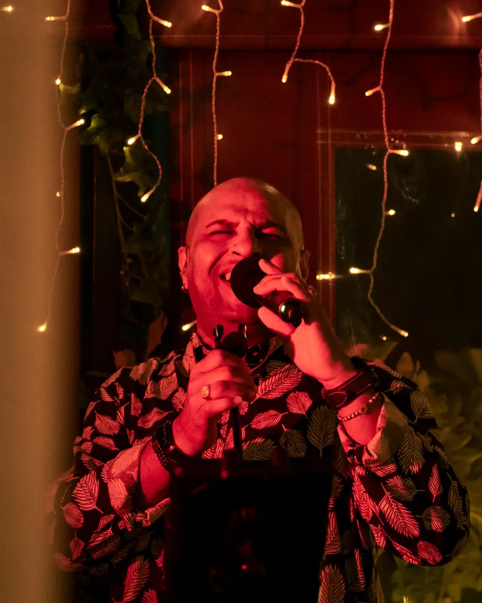 A vocalist mid-song in red light at Pachamama
